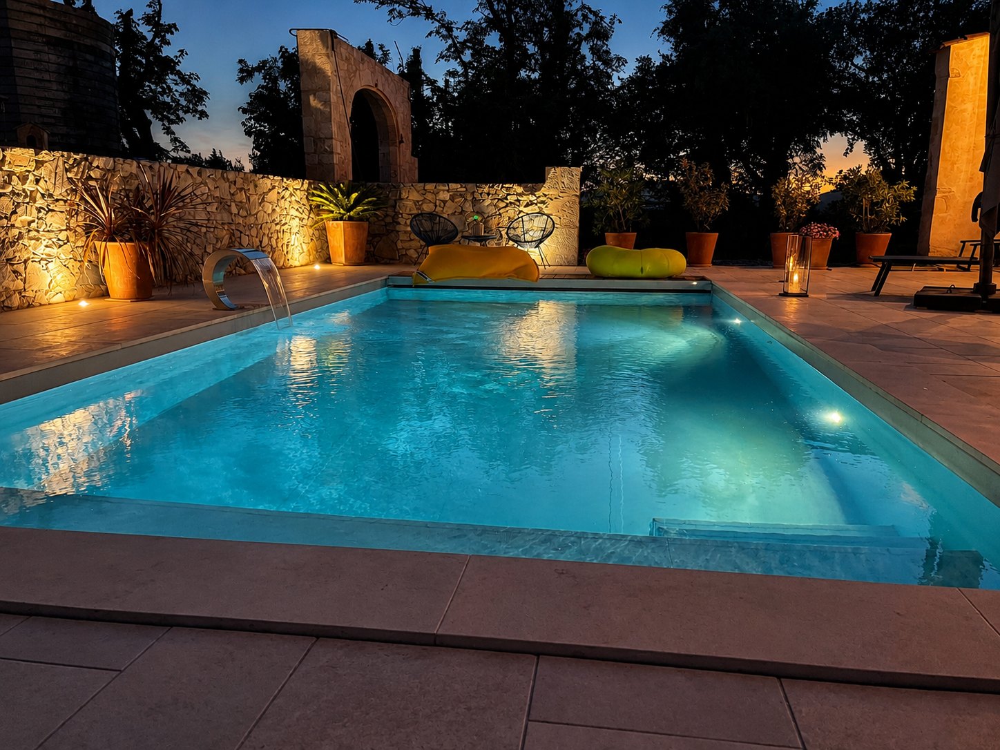 Piscine réalisée avec mise en lumière et murs en pierre